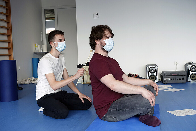 Antoine Thomas, étudiant psychomotricien, pratique un exercice d'eutonie, avec un « solé » sur le dos de Romain Wintz, personnel participant. 