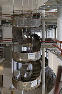La rampe métallique centrale permet d’accéder aux différents niveaux de la bibliothèque.